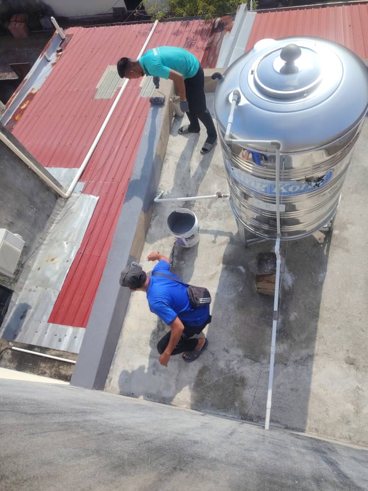 Pekerja menyapu salutan kalis air di sekeliling tangki air